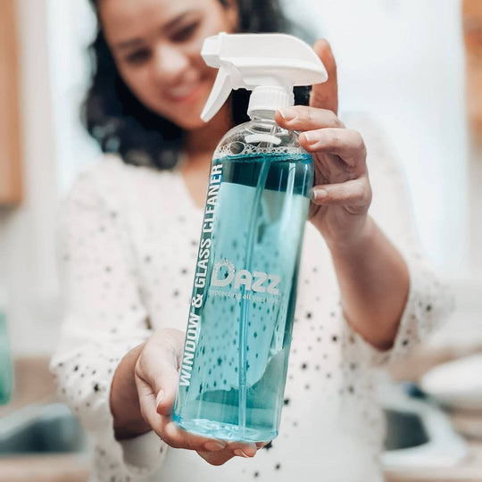 Woman holding a refillable DAZZ Window & Glass spray bottle